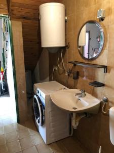 a bathroom with a sink and a washing machine at Apartments by the sea Susak, Losinj - 14713 in Susak