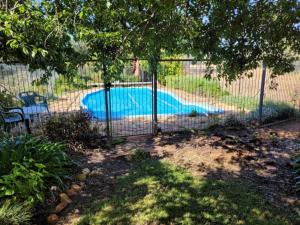 a fence around a swimming pool in a yard at Eccles - Rustic style accommodation with Mod Cons in Hoddy Well