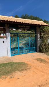 a blue gate in front of a building at Aconchegante casa em Monte Verde in Monte Verde