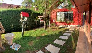 un patio trasero con un árbol y una casa de pájaros en Aconchegante casa em Monte Verde, en Monte Verde