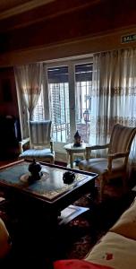 Quinta Ugarte في سيوداد لوجان دي كويو: غرفة معيشة مع أريكة وطاولة وكراسي