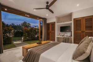1 dormitorio con cama y ventana grande en Umah Shama en Ubud