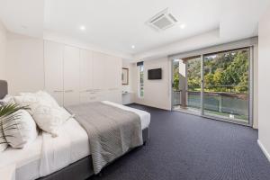 una camera da letto con un letto grande e una grande finestra di 31 Witta Circle, Noosa Heads a Noosa Heads Altre 19 foto