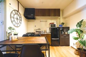 een keuken met een houten tafel en een koelkast bij Rose Heights Higashimoto - Vacation STAY 8157 in Osaka