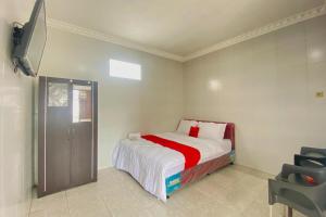 a bedroom with a bed and a flat screen tv at RedDoorz Plus near Cito Mall Surabaya in Siwalapkerto