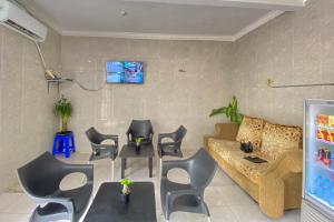 a living room with a couch and chairs at RedDoorz Plus near Cito Mall Surabaya in Siwalapkerto