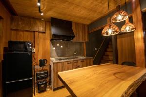 una cocina con una mesa de madera y algunas luces en Osaka - House - Vacation STAY 8296, en Osaka