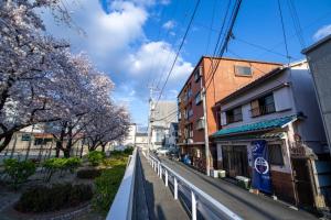 Una calle de la ciudad con árboles akura en primer plano en Osaka - House - Vacation STAY 8296, en Osaka