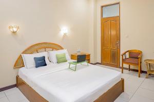 Tempat tidur dalam kamar di Urbanview Hotel Gading Kencana Samarinda by RedDoorz