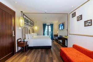 Habitación de hotel con cama blanca y escritorio en Hanoi Calista Hotel en Hanoi