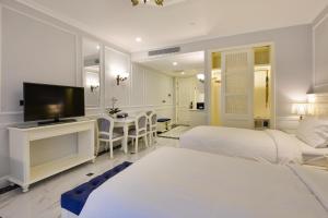 a hotel room with two beds and a television at Lan Rung Resort Phuoc Hai in Long Hai