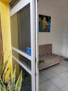 a sliding glass door to a room with a couch at Pousada Maraki in Maceió