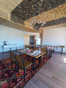 uma grande sala de jantar com mesas e cadeiras e um quadro branco em Kezgin Guest House em Naryn