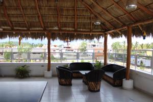 a patio with chairs and a table and a balcony at Hotel & Suites VAYOR in San Patricio Melaque