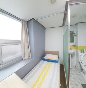 um pequeno quarto com uma cama e um WC em Apgujeong Home em Seul