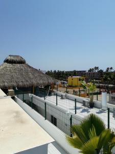 Hotel & Suites VAYOR في سان باتريسيو ميلاكي: منتجع فيه مسبح وسقف من القش