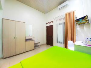 a room with a green table and a kitchen at Hometown Residence in Bandar Lampung