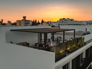a rooftop terrace with a view of the city at sunset at Armonta Residences by BeCyprus in Limassol