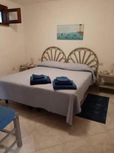 a bedroom with a bed with blue towels on it at Appartamento Semi-Interrato Masi in Torre Dei Corsari