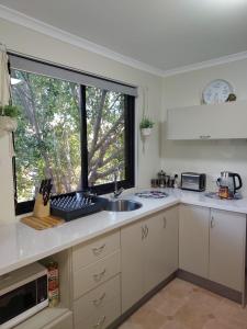 a kitchen with a sink and a window at Almost Off Grid Tranquillity in Katherine