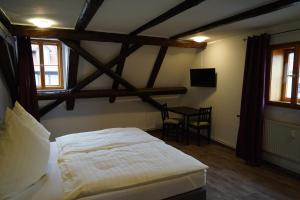 a bedroom with a bed and a table in it at Kaufmannshaus Anno 1613 in Quedlinburg