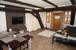 a living room with a table and a dining room at Kaufmannshaus Anno 1613 in Quedlinburg