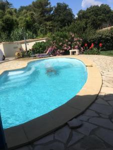 a swimming pool with blue water in a yard at Le mazet in La Londe-les-Maures