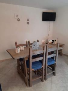 a wooden table with chairs and a television in a room at Appartamento Semi-Interrato Masi in Torre Dei Corsari