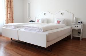 فندق فايسيس كروز في إنترلاكن: غرفة نوم بيضاء بسريرين بيض وطاولة