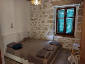 een slaapkamer met een bed in een kamer met een raam bij Apartments Tonci - 30 m from beach in Kali