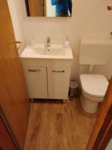 een badkamer met een witte wastafel en een toilet bij Apartments Tonci - 30 m from beach in Kali