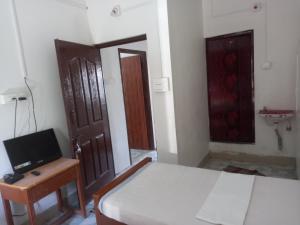 Parisha Residency- Temple Side Hotel的电视和/或娱乐中心