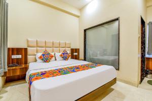 a bedroom with a large bed with a large window at FabExpress Dosa Plaza in Udaipur