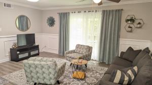 a living room with a couch and chairs and a tv at Cute Apt near Atlanta Airport-3A in Atlanta