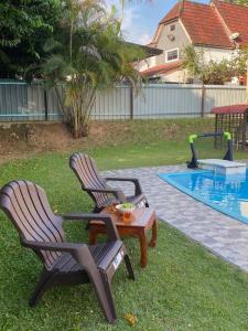 2 sedie e un tavolo accanto alla piscina di Villa Teratai 878 @ A'Famosa Resort a Kampong Alor Gajah