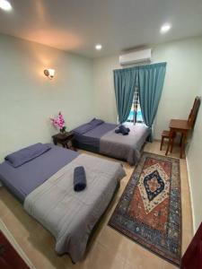 a bedroom with two beds and a window at Villa Teratai 878 @ A'Famosa Resort in Kampong Alor Gajah
