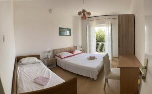 1 dormitorio con 2 camas y ventana en Apartments by the sea Lun, Pag - 9395 en Lun