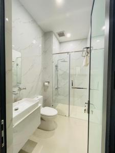 La salle de bains blanche est pourvue d'une douche et de toilettes. dans l'établissement Khách sạn Sớm Phú Quý 2 - Phan Rang, à Phan Rang