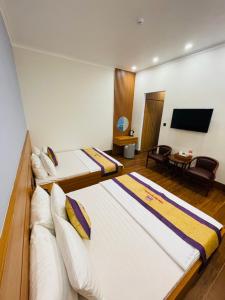 Cette chambre comprend 2 lits et une télévision à écran plat. dans l'établissement Khách sạn Sớm Phú Quý 2 - Phan Rang, à Phan Rang