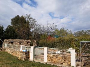 uma parede de pedra com um portão e uma cerca em villa au calme à l'entrée d'Uzès em Serviers-et-Labaume