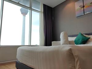 um quarto de hotel com uma cama e vista para uma torre em Vortex Suites KLCC By Welt em Kuala Lumpur