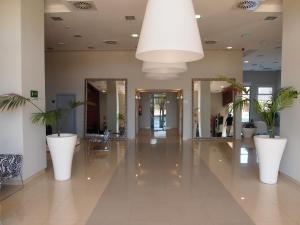 a hallway with mirrors and potted plants in a building at Apartamentos Europa House Sun Beach in Guardamar del Segura