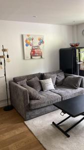 a living room with a gray couch and a table at Le Week-End 3 étoiles, plein centre ville in La Clusaz