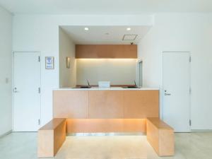 a kitchen with a bench in the middle of a room at Hotel Isesaki East in Isesaki