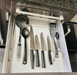 a drawer full of knives and spatulas in a drawer at Forum de Barcelona Sea View Apartment with Garage Parking in Sant Adria de Besos