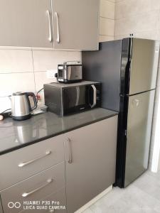 a kitchen with a microwave and a refrigerator at Amazing 2BR pent house flat with mountain view in Muscat