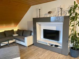 een woonkamer met een bank en een open haard bij Ferienwohnung mit Ausblick in Mömbris