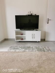 a white entertainment center with a flat screen tv at Amazing 2BR pent house flat with mountain view in Muscat