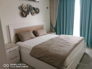 una camera da letto con un grande letto con tende blu di Amazing 2BR pent house flat with mountain view a Mascate