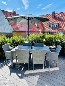 une table et des chaises avec un parasol sur une terrasse dans l'établissement Schöne Ferienwohnungen teilweise mit Dachterrasse im Herzen von Itzehoe, à Itzehoe